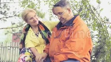 一对成年夫妇坐在公园里的长凳上，一个女人小心翼翼地调整头发给她的丈夫。 慢动作。 <strong>1920</strong>x1080。 高清高清